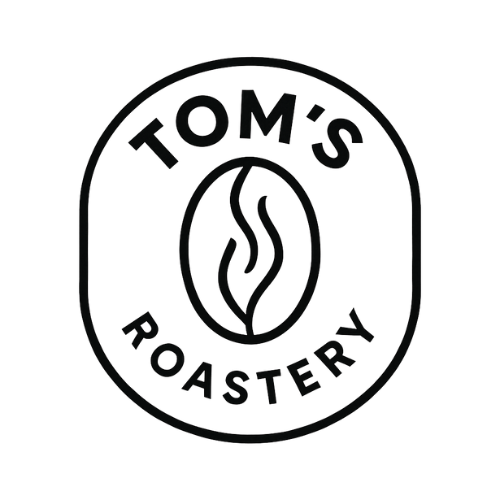 A rounded vertical oval boarder and the center is a minimalistic drawing of a coffee bean. There is text above and below the coffee bean reading "Tom's Roastery".